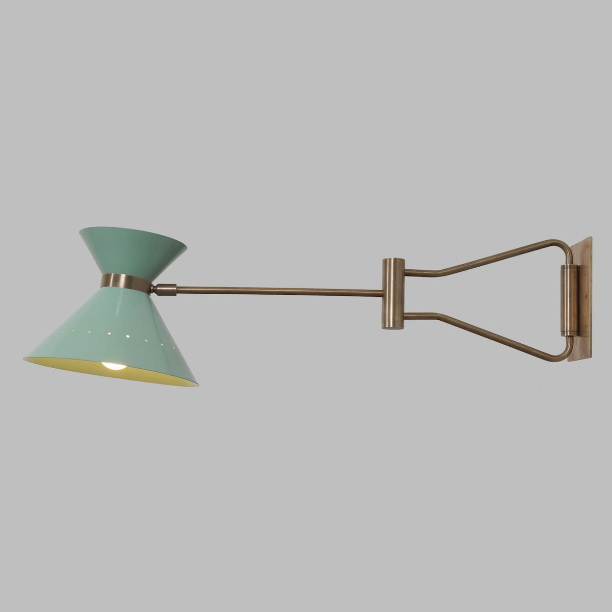 Adjustable brass swing arm wall lamp extended in opposite direction, highlighting flexible movement and balanced industrial design.