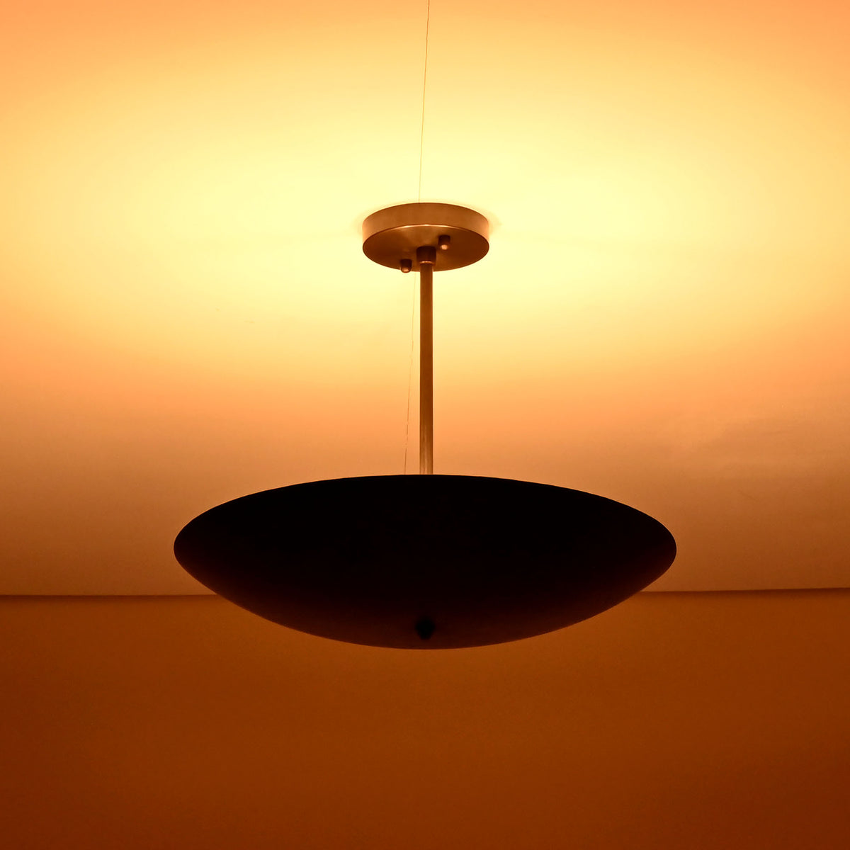 Ambient brass ceiling chandelier radiating soft warm light across the ceiling