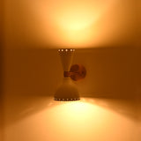 Mid century inspired Amsterdam wall sconce with hourglass silhouette, perforated shades and raw brass details