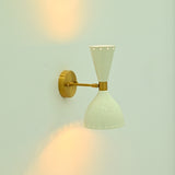 Decorative perforated wall sconce with small openings around the enamel shade edges and warm light effect