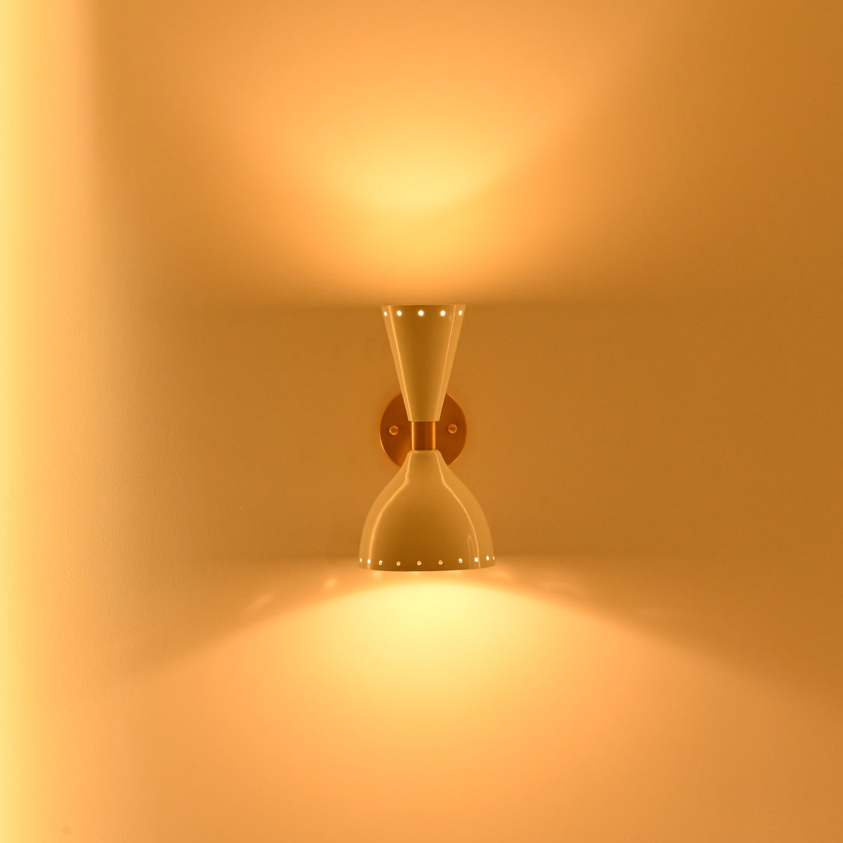 Amsterdam double cone wall sconce used beside a vanity mirror with warm up and down lighting