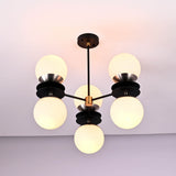 Side angle of modern brass and black chandelier with six round opal glass globes