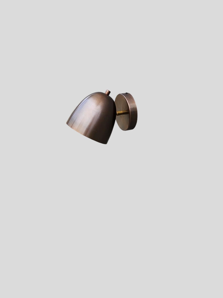 Minimalist industrial brass wall light in antique patina finish, adjustable angle view
