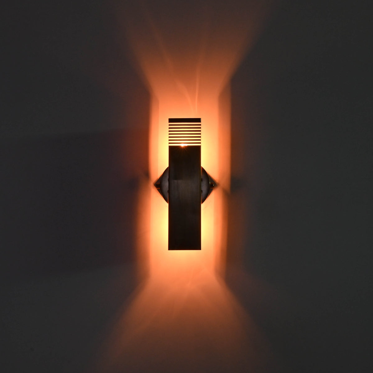 Architectural brass wall wash light with vertical rectangular shape and warm upward and downward glow for modern interiors