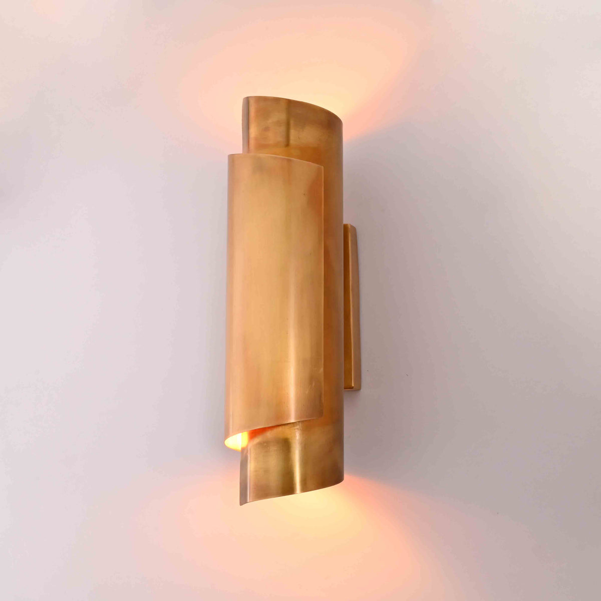 Arcus brass ribbon wall sconce shown in office interior with warm up and down ambient glow