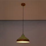Artistic copper hanging pendant light with green patina finish, black suspension cord, and wide shallow dome shade