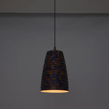 Artistic ribbed pendant light adding warm ambient glow to a stylish interior with wooden furniture and soft décor