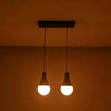 Angled illuminated view of the Aspen Dual Socket Pendant Chandelier with two glowing globe bulbs in a modern minimalist design.