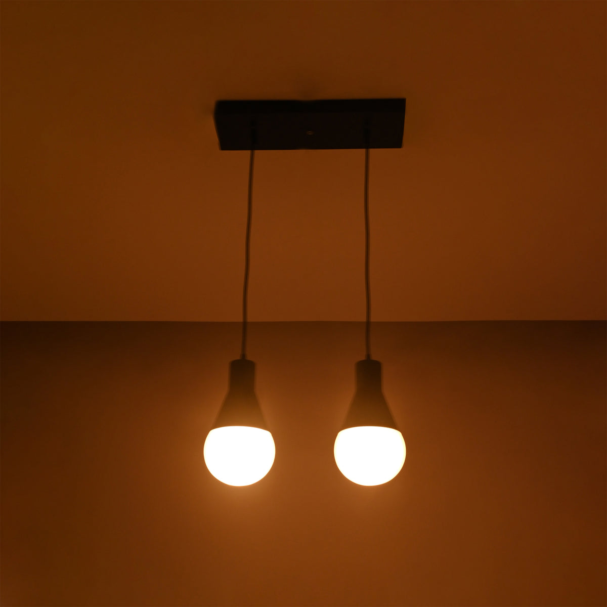 Aspen Dual Socket Pendant Chandelier Model 33242 illuminated against a dark background, showcasing warm ambient lighting.