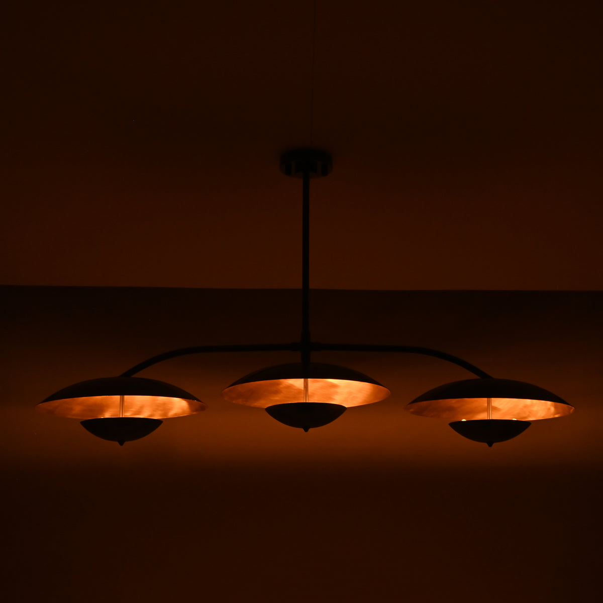 Astra Halo 3 light modern chandelier with black curved arms and warm reflective shade interiors