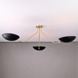 Front angled view of asymmetrical brass chandelier with matte black bowl shades and handcrafted brass rods.