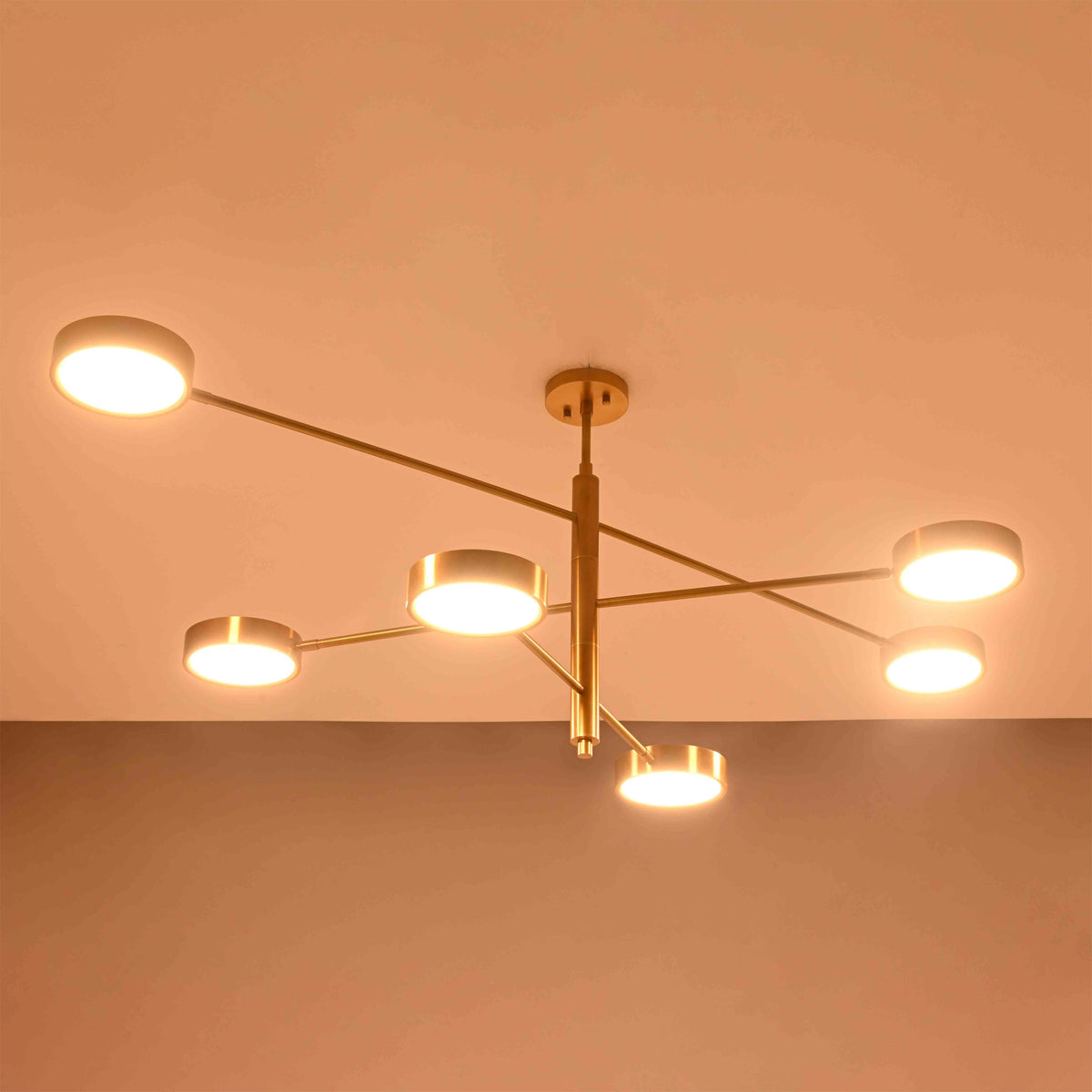 Athens 6-light disc chandelier shown from side angle with tiered brass rods and round illuminated heads