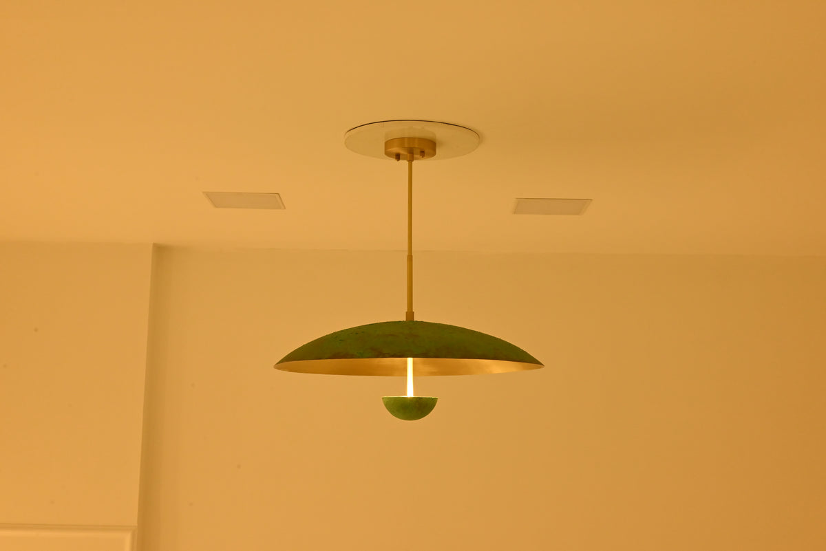 Sculptural dome ceiling light with brushed brass interior, verdigris exterior and central illuminated stem