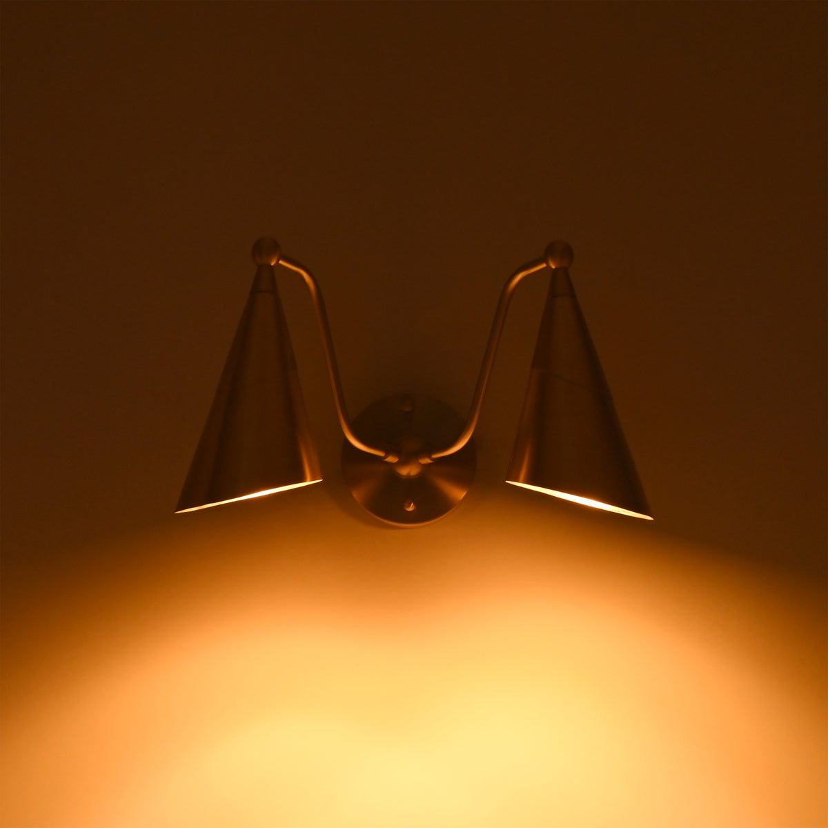 Aurelia brass wall sconce with dual tapered cone shades and decorative ball accents for modern and transitional interiors