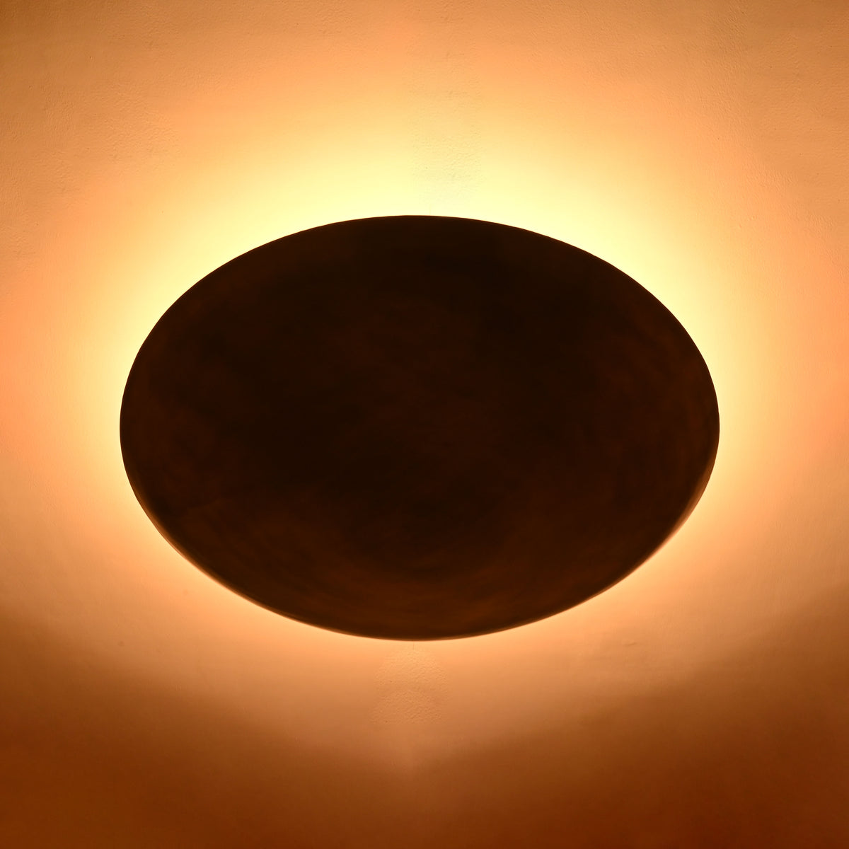 Low profile brass ceiling fixture with broad shallow bowl shade and warm ambient lighting