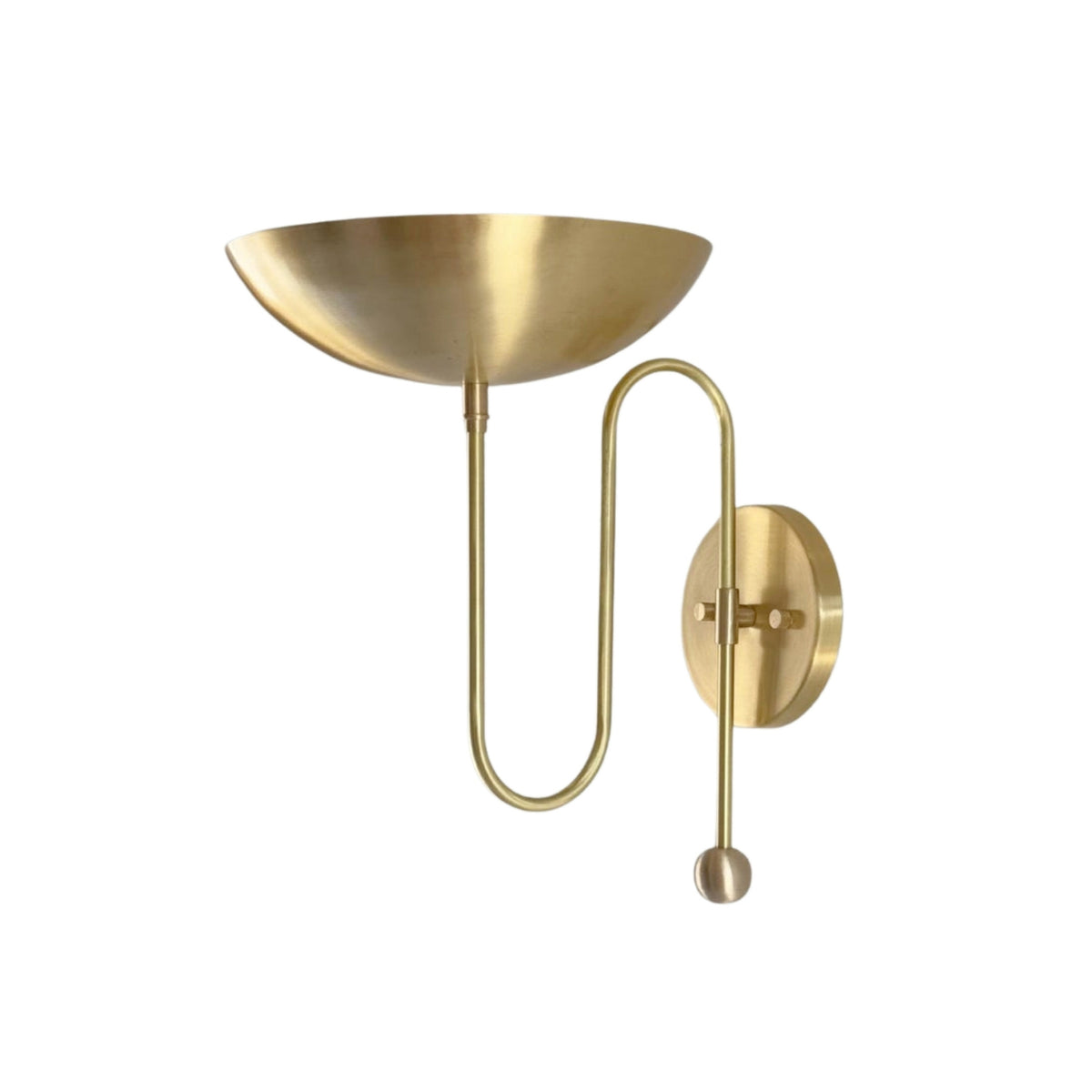 Side profile of the Aurora modern brass bowl wall sconce highlighting its sculptural bowl shade, loop arm, and wall-mounted construction.