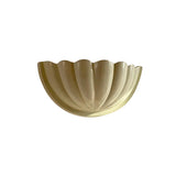 Angled view of the Aurora modern ivory fluted half bowl wall sconce showcasing its elegant fluted profile and minimalist design.