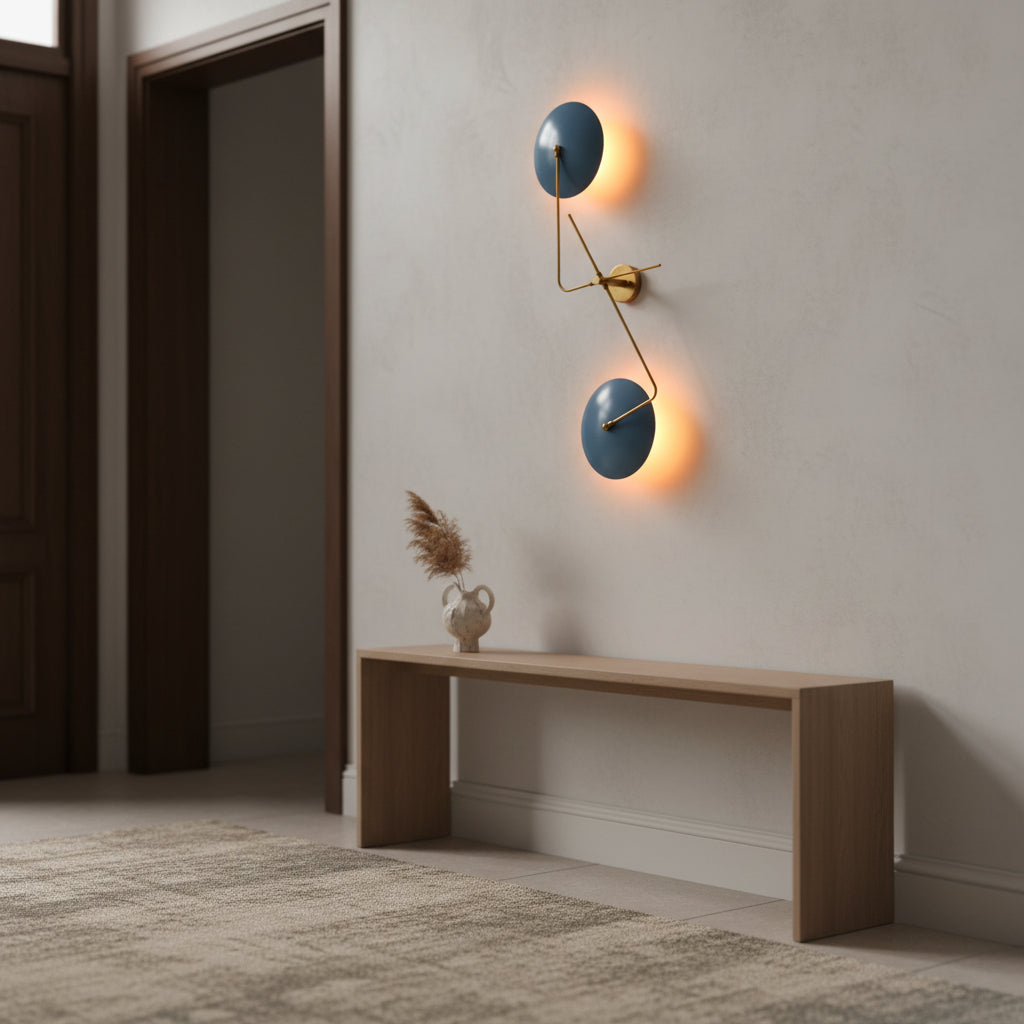 Closeup of backlit blue disc wall sconce showing warm ambient glow and sculptural brass detailing
