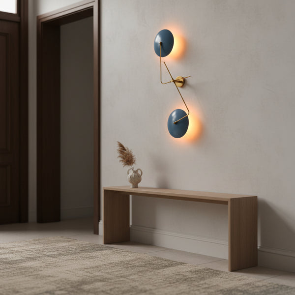 Closeup of backlit blue disc wall sconce showing warm ambient glow and sculptural brass detailing