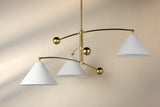 Balance brass chandelier installed in modern interior showing warm ambient lighting and sculptural brass arms