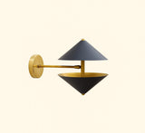 Designer black and brass wall sconce with sculptural double cone silhouette providing warm ambient upward and downward lighting.