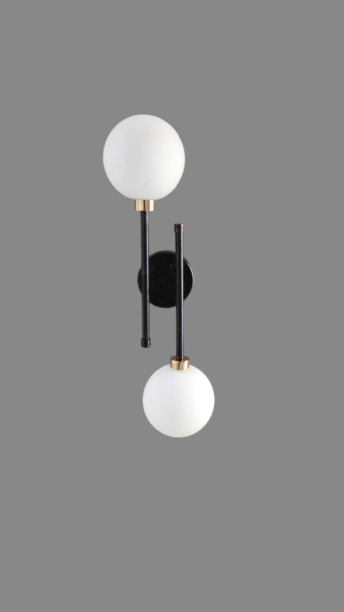 Product shot of handcrafted black and brass double globe wall light by Brass Leaf Studio showcasing elegant symmetry.