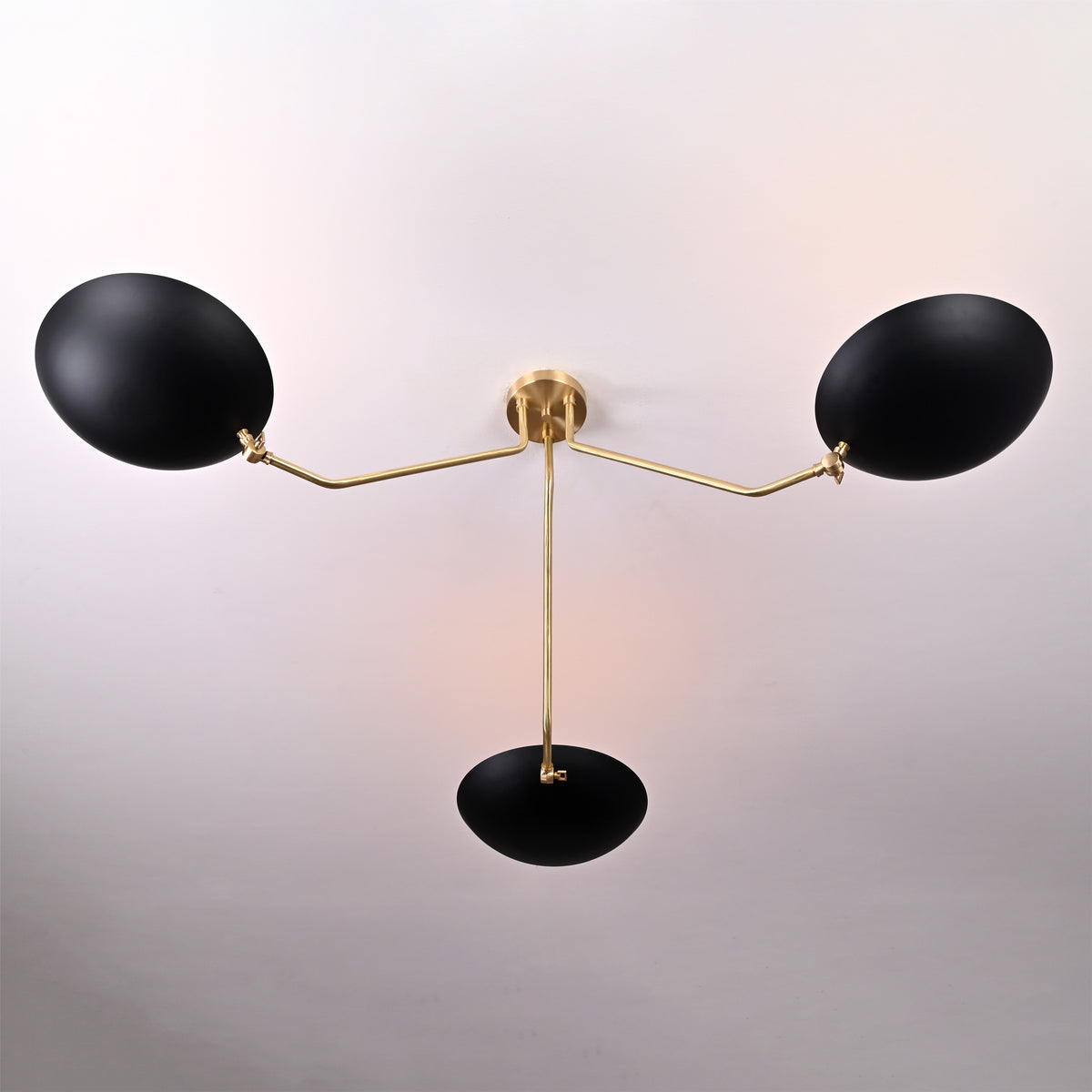Top view of black and brass bowl chandelier showing elegant curvature of the brass arms and central support.