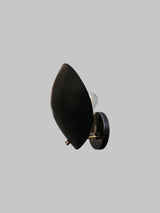 Black brass leaf-shaped wall sconce with bulb partially visible