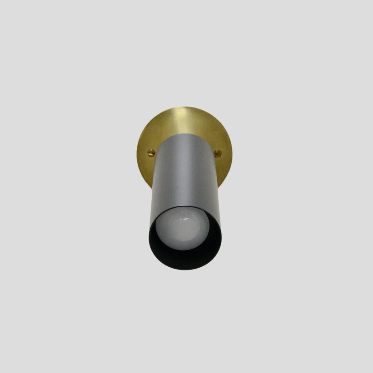 Cylindrical black spotlight with brass mount viewed from below, ideal for directional lighting