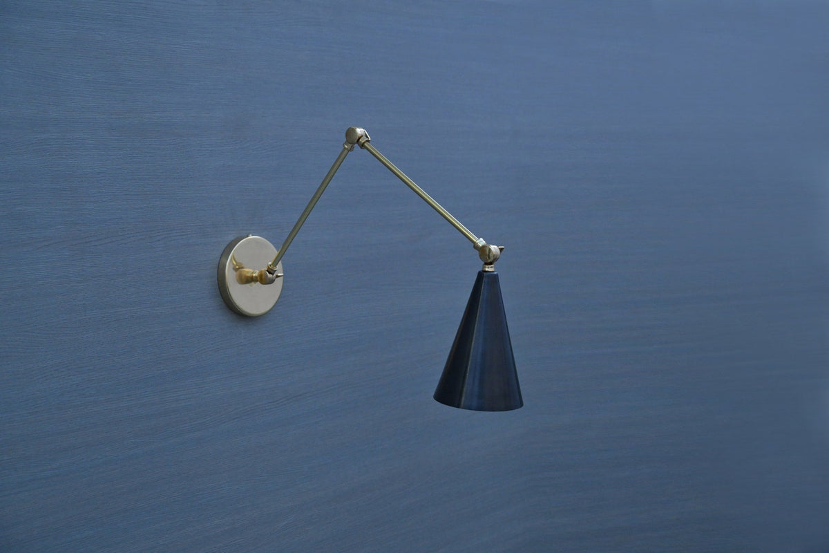 Minimalist brass swing arm wall sconce with cone-shaped black shade