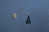 Minimalist brass swing arm wall sconce with cone-shaped black shade