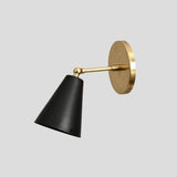 Modern black cone wall sconce with solid brass base, handmade industrial lighting fixture, side angle view.