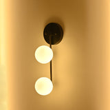 Blackened brass wall light with two frosted glass globes and a clean vertical profile for modern interior lighting