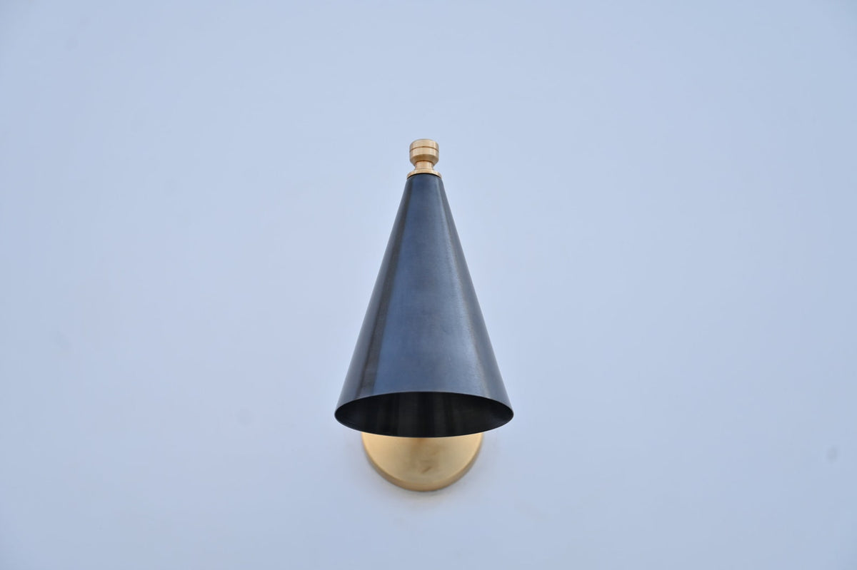 Front view of blackened brass cone wall light showing minimalist tapered shade and golden brass fixture.