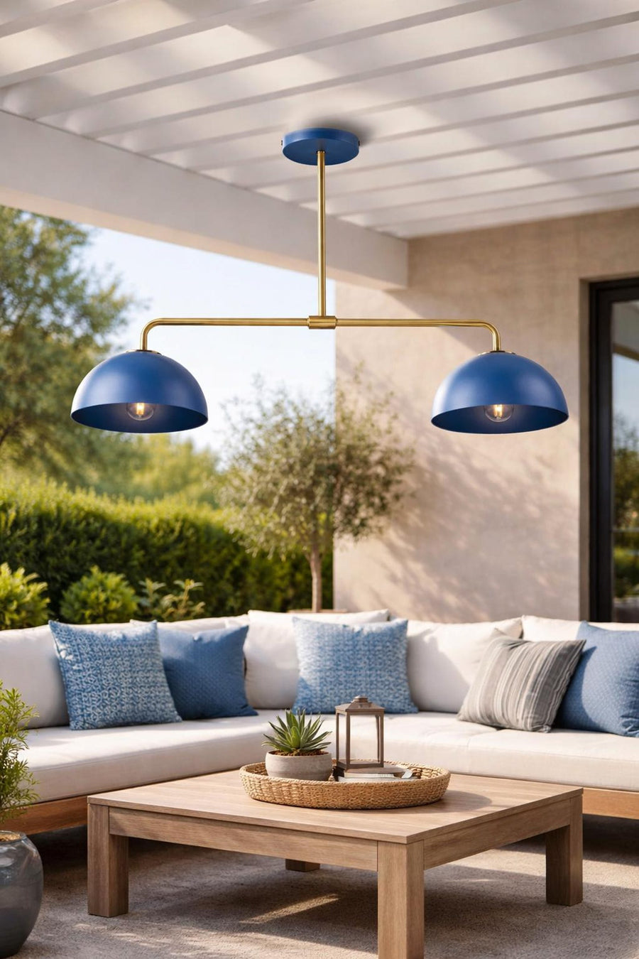 Modern blue double dome chandelier in solid brass finish hanging over a wooden dining table with elegant table setting.