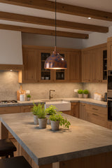 Blue copper dome pendant lamp installed above a kitchen island with warm downward light and decorative patina finish