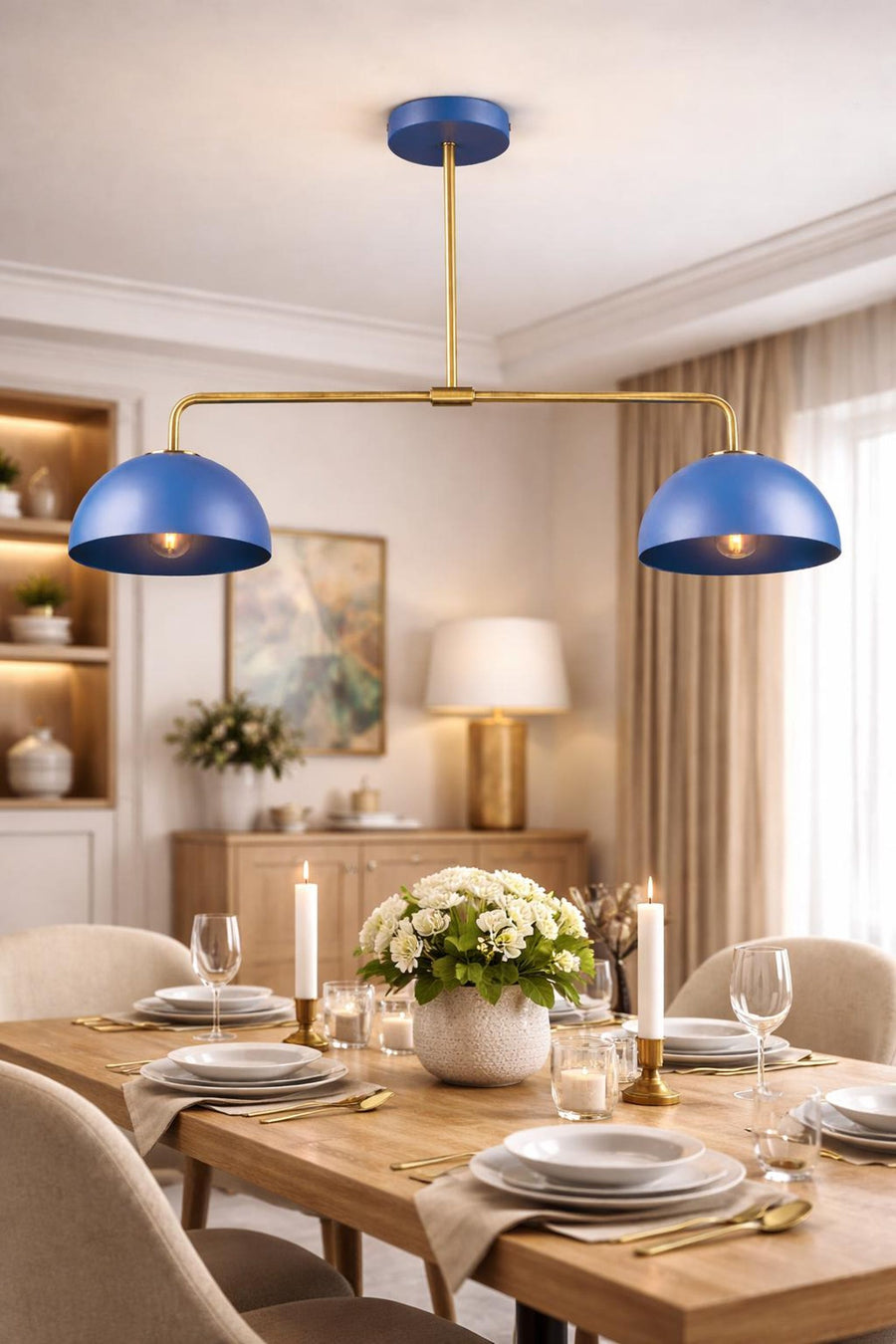 Modern blue double dome chandelier in solid brass finish hanging over a wooden dining table with elegant table setting.