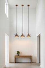Closeup of blue patina copper pendant shade showing exposed copper tones, rounded dome shape, and warm inner glow