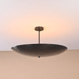 5-light brass ceiling fixture glowing in dark room with soft ambient lighting