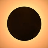 Overhead view of bowl-shaped brass ceiling light with warm ambient glow