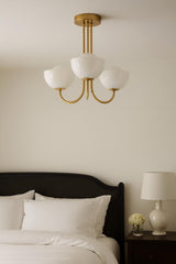 Solid brass 3-light bowl glass chandelier installed above a bed with soft ambient bedroom lighting