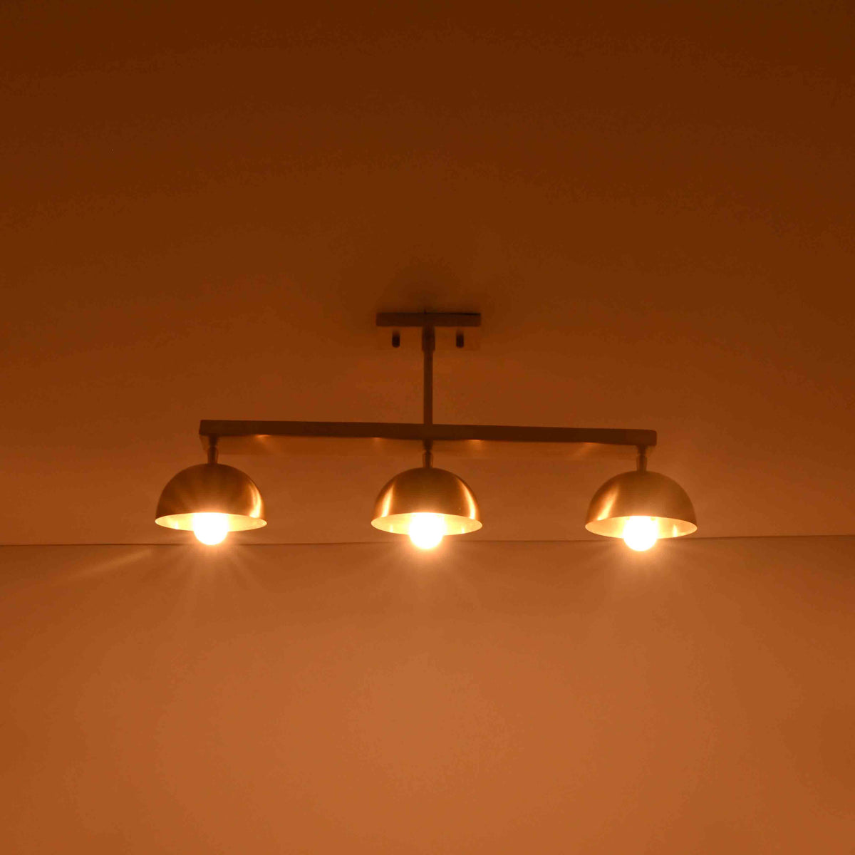 Three light ceiling fixture shown illuminated, creating warm downward glow for bedrooms, dining rooms, and living spaces
