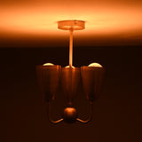 Brass 3-light chandelier emitting soft warm illumination, showcasing elegant cup shades and a minimalist brass stem.