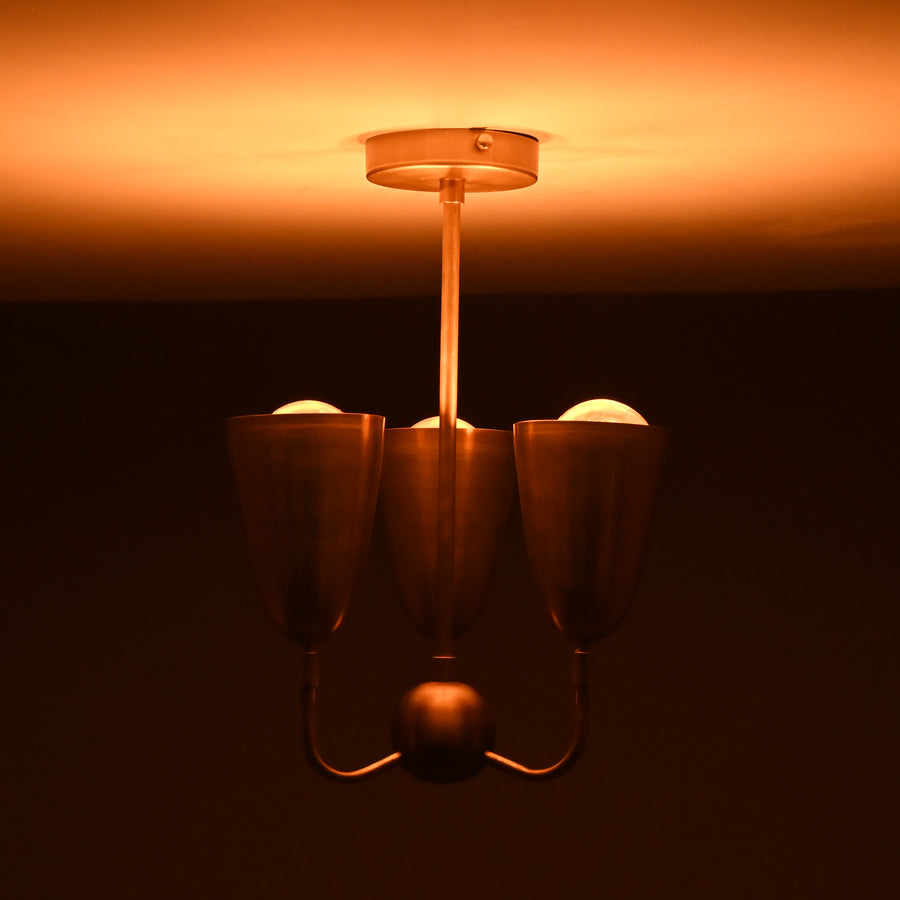 Main view of brass 3-light flushmount chandelier with sculpted cup shades and minimalist brass frame.