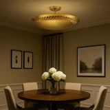 3 light brass disc style flush mount chandelier installed above a dining table