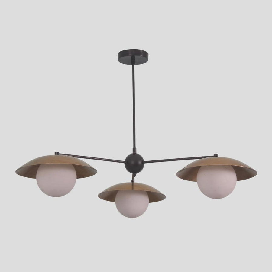 Modern brass chandelier with three globe lights and bowl-shaped shades, minimalist pendant design for dining and living spaces.