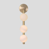 Modern handmade brass wall light with three frosted glass globe shades, vertical sconce straight-on view