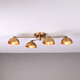 Handmade brass ceiling light with four dome-shaped shades illuminated, modern low-profile 4-light fixture for living room or hallway.