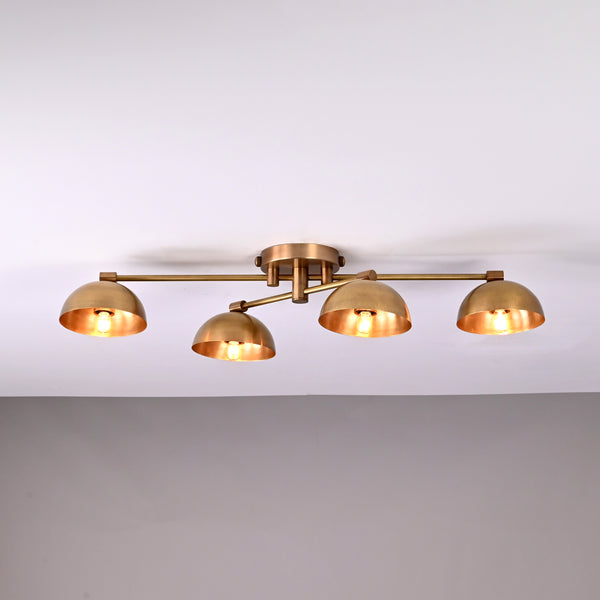 Handmade brass ceiling light with four dome-shaped shades illuminated, modern low-profile 4-light fixture for living room or hallway.