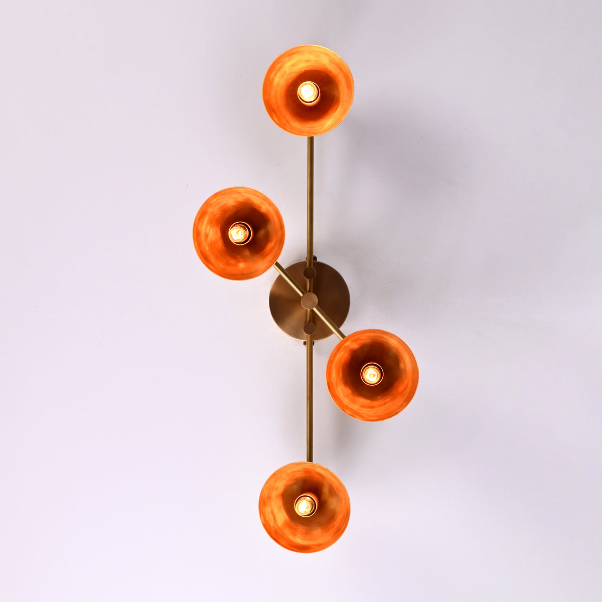 Overhead view of four-light brass bowl shade chandelier spreading ambient warm light, handcrafted flushmount fixture.